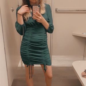 Fitted green formal mid rise dress with long sleeves past elbows.